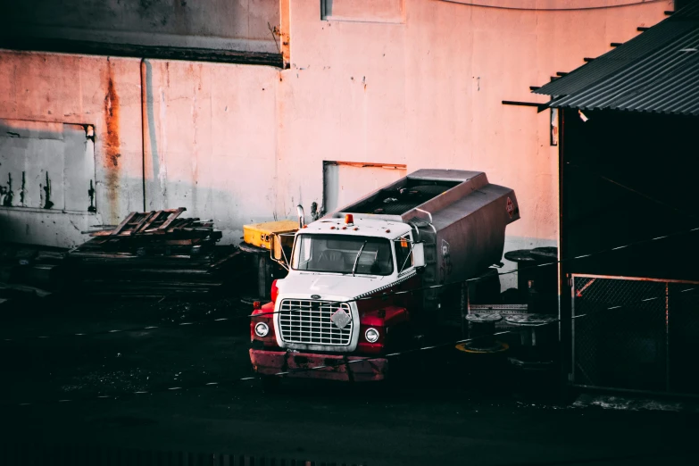 a dump truck parked in front of a building, inspired by Elsa Bleda, pexels contest winner, renaissance, white and red body armor, evening mood, iron and asphalt, 1 2 9 7