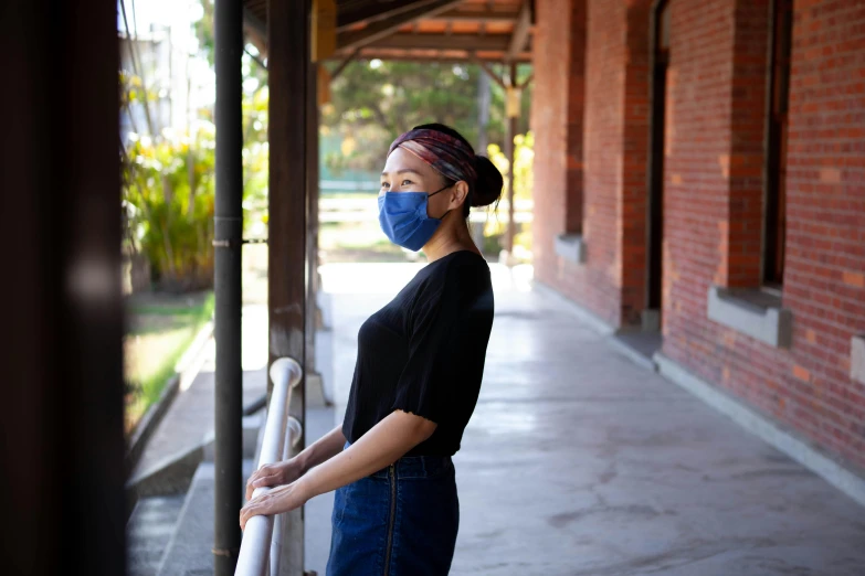 a woman wearing a face mask standing on a porch, calarts, profile image