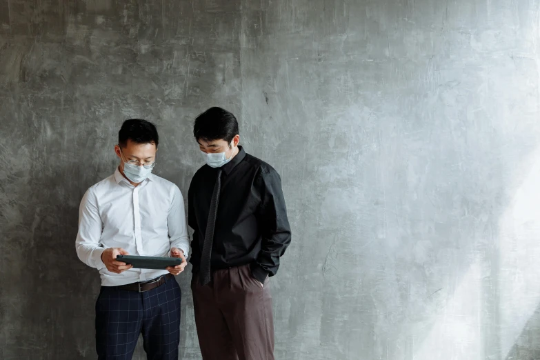 a couple of men standing next to each other, by Jang Seung-eop, pexels contest winner, medical mask, holding notebook, developers, grey