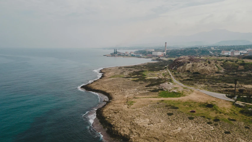 a large body of water next to a beach, by Daniel Lieske, pexels contest winner, les nabis, factories and nature, cyprus, pov photo