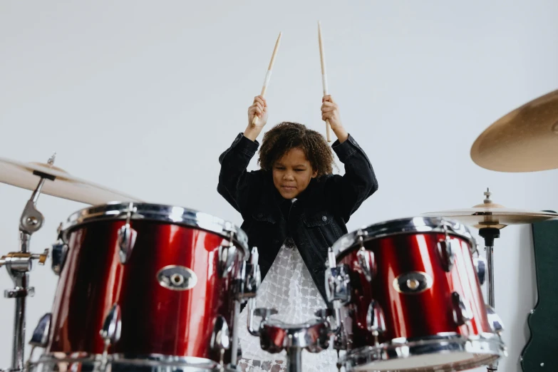 a little girl that is standing in front of a drum set, pexels contest winner, antipodeans, avatar image, diverse, high quality image, profile image