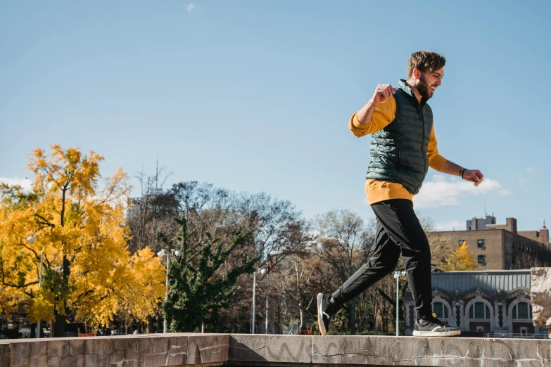 a man riding a skateboard up the side of a ramp, unsplash, autumnal, in a jumping float pose, walking at the park, federation clothing