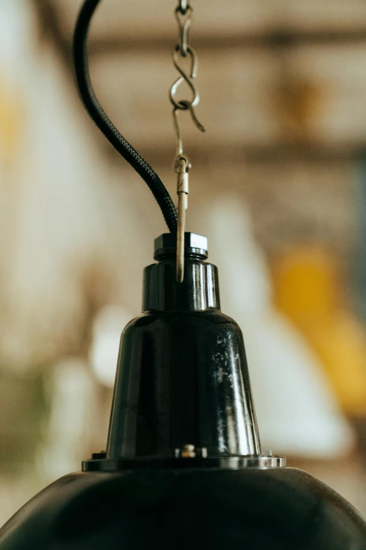 a black light hanging from a ceiling in a room, by Sven Erixson, unsplash, carbide lamp, detailed product image, bottom body close up, upcycled