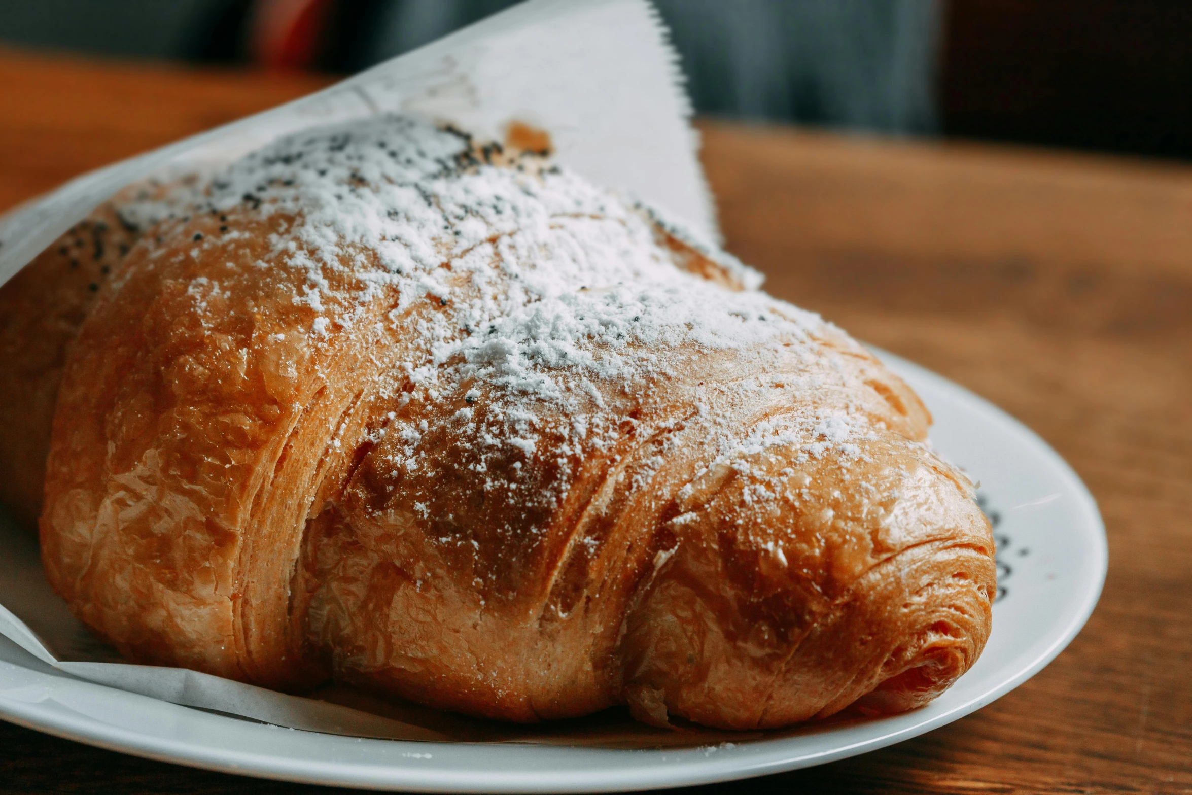 a white plate topped with a pastry covered in powdered sugar, unsplash, fan favorite, traditional corsican, wrinkled, a gigantic