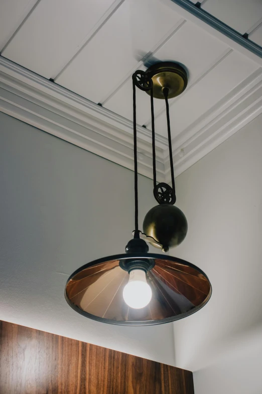 a couple of lights hanging from the ceiling, tall ceilings, vintage shading, mechanical detail, dual tone lighting