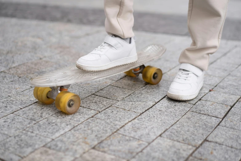 a person standing on a skateboard on a sidewalk, white metallic, walkable, schools, slick tires