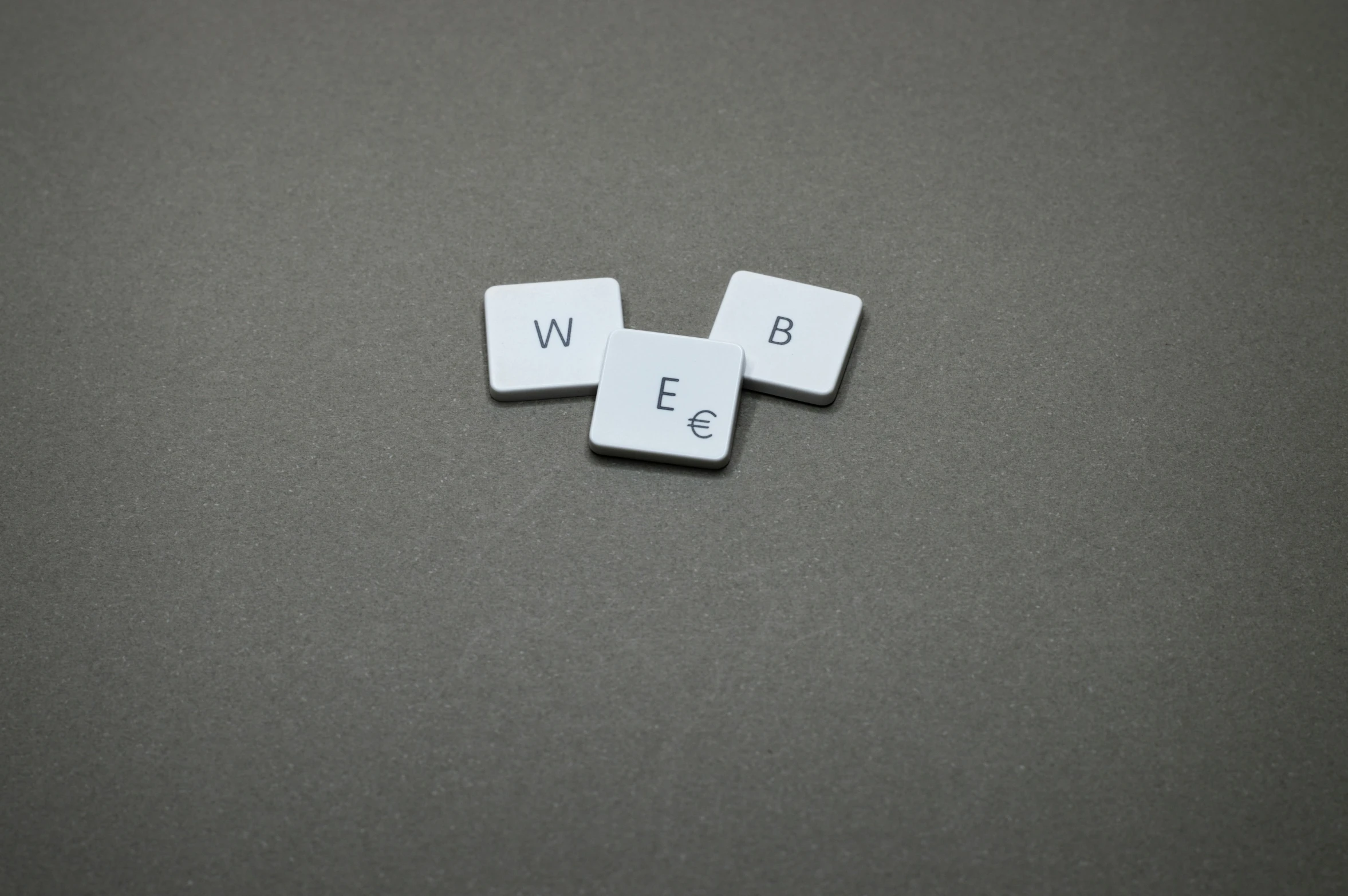 a couple of dice pieces sitting on top of a table, web design, the letter w, webs, grey