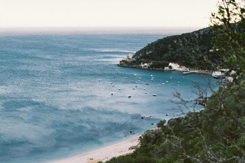 a view of a beach from the top of a hill, unsplash contest winner, with water and boats, 2000s photo, sydney hanson, abel tasman