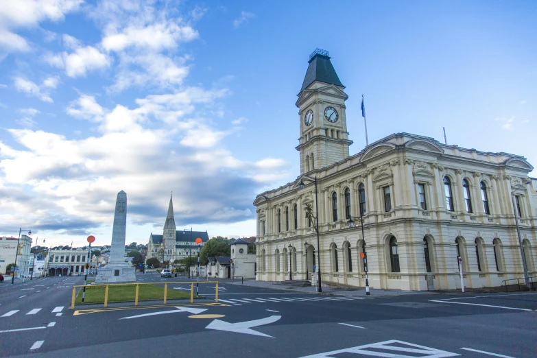 a large building with a clock tower on top of it, inspired by James Ardern Grant, city in background, holding court, square, high-quality photo