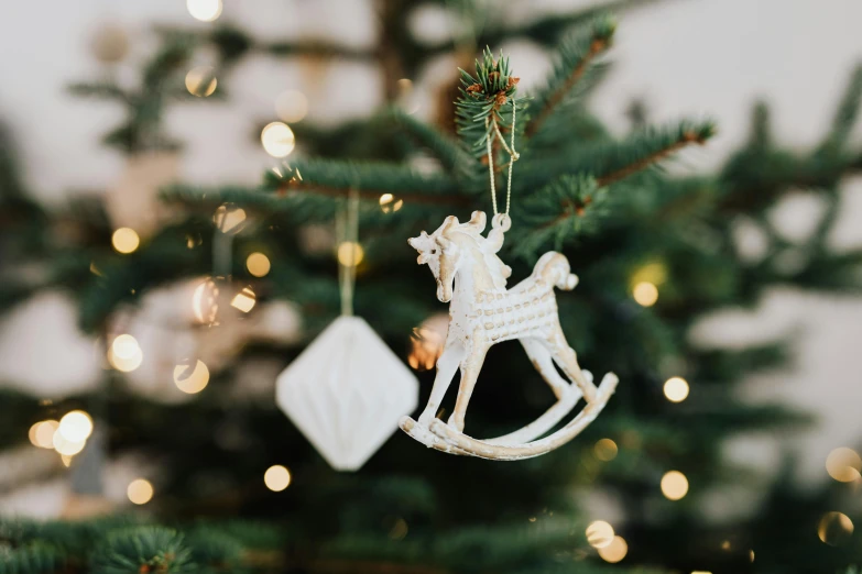 a white rocking horse ornament hanging from a christmas tree, pexels, arabesque, fossil ornaments, getty images, jen atkin, extremely high resolution