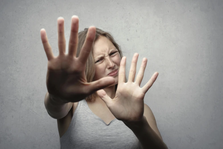 a woman making a stop sign with her hands, grey, looking threatening, square, antidisestablishmentarianism