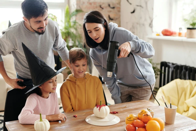 a group of people standing around a table with a cake on it, an airbrush painting, pexels contest winner, 🍁 cute, food. craft and adventure, at home, carving