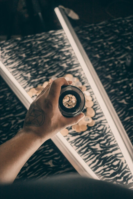 a person holding a camera in front of a mirror, seen through a kaleidoscope, taking tobacco snuff, dramatic lighting from above, curated collections