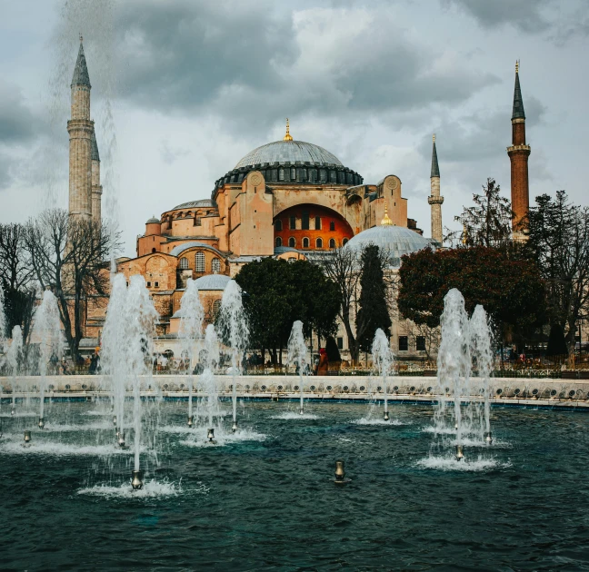 a large building with a fountain in front of it, a colorized photo, pexels contest winner, hurufiyya, minarets, 🚿🗝📝