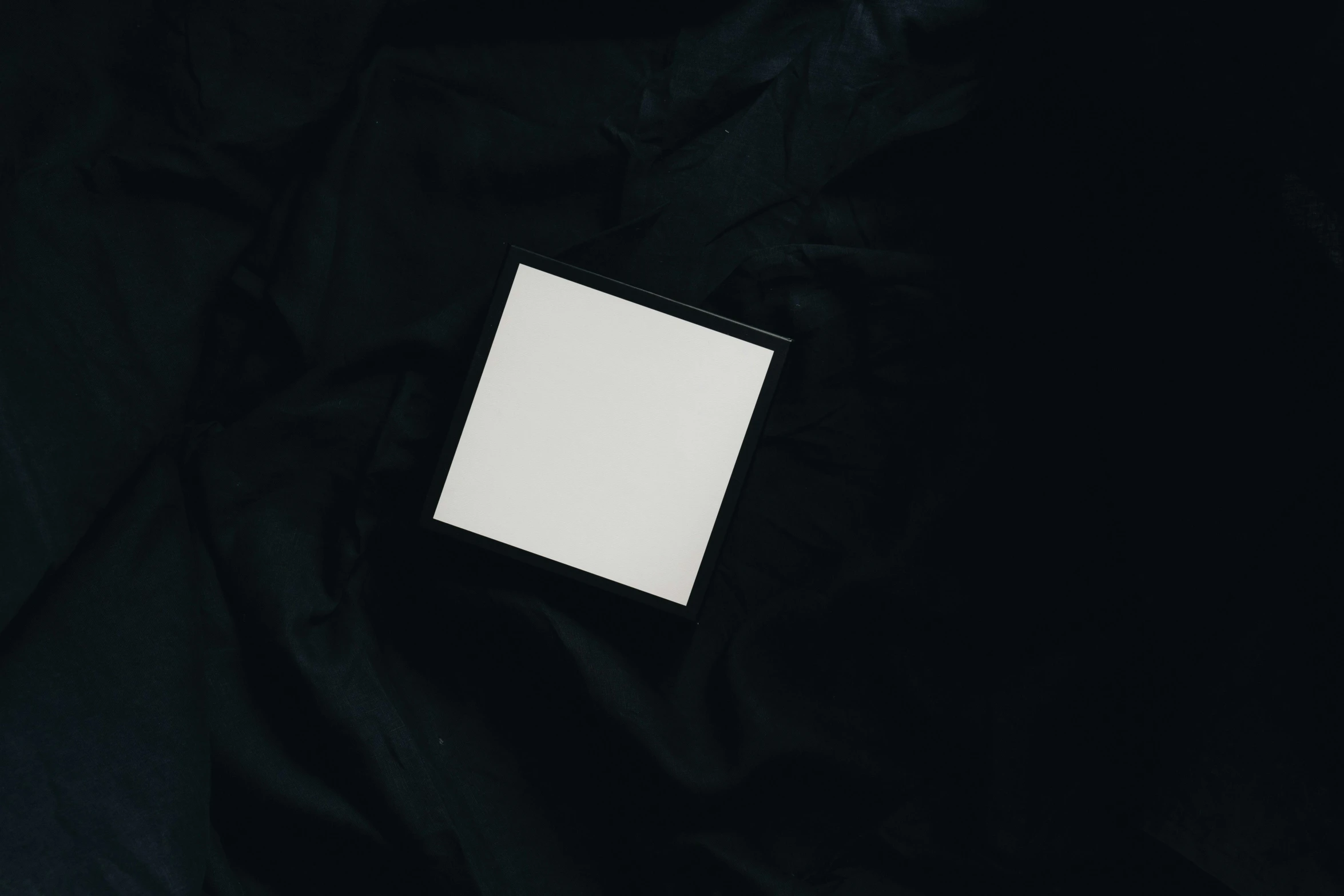 a laptop computer sitting on top of a black cloth, an album cover, inspired by Malevich, trending on pexels, white cloth, black and white polaroid, square face, white box