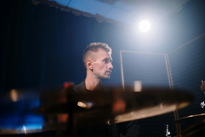 a man that is sitting in front of a drum, a portrait, unsplash, photorealism, autechre, keyboardist, 15081959 21121991 01012000 4k, melanchonic soft light