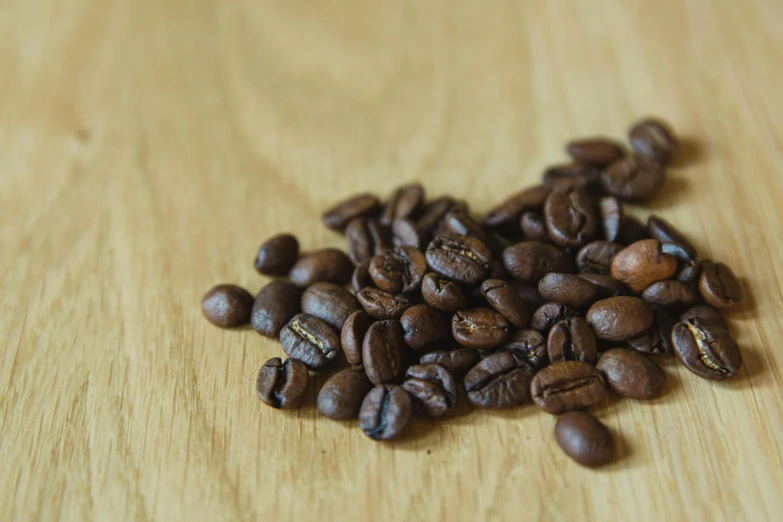 a pile of coffee beans sitting on top of a wooden table