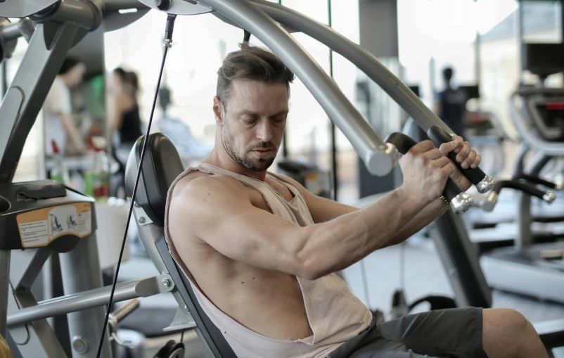 a man working out on a machine in a gym, a photo, by Adam Marczyński, renaissance, thumbnail, high quality image, extremely graphic, concept photo
