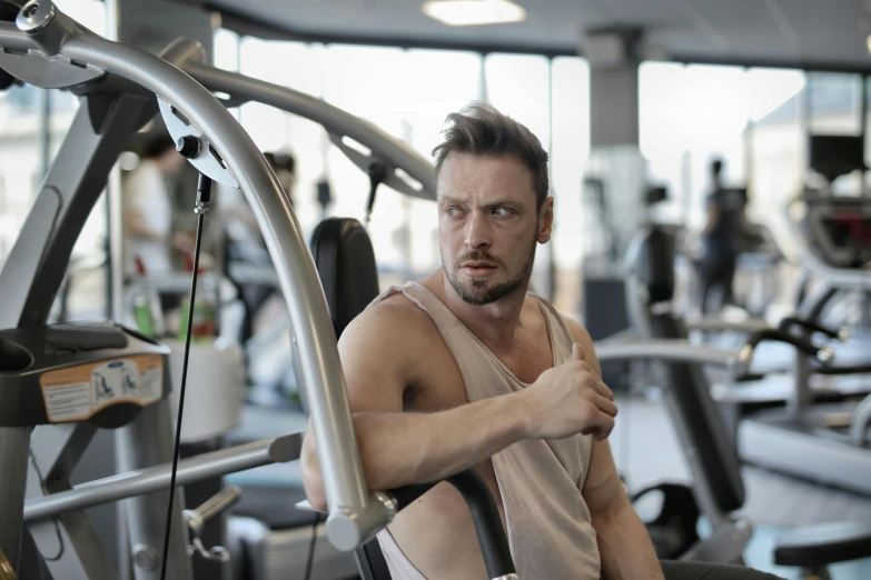 a man sitting on top of a machine in a gym, pexels contest winner, renaissance, manly face, annoyed, 30 year old man :: athletic, avatar image