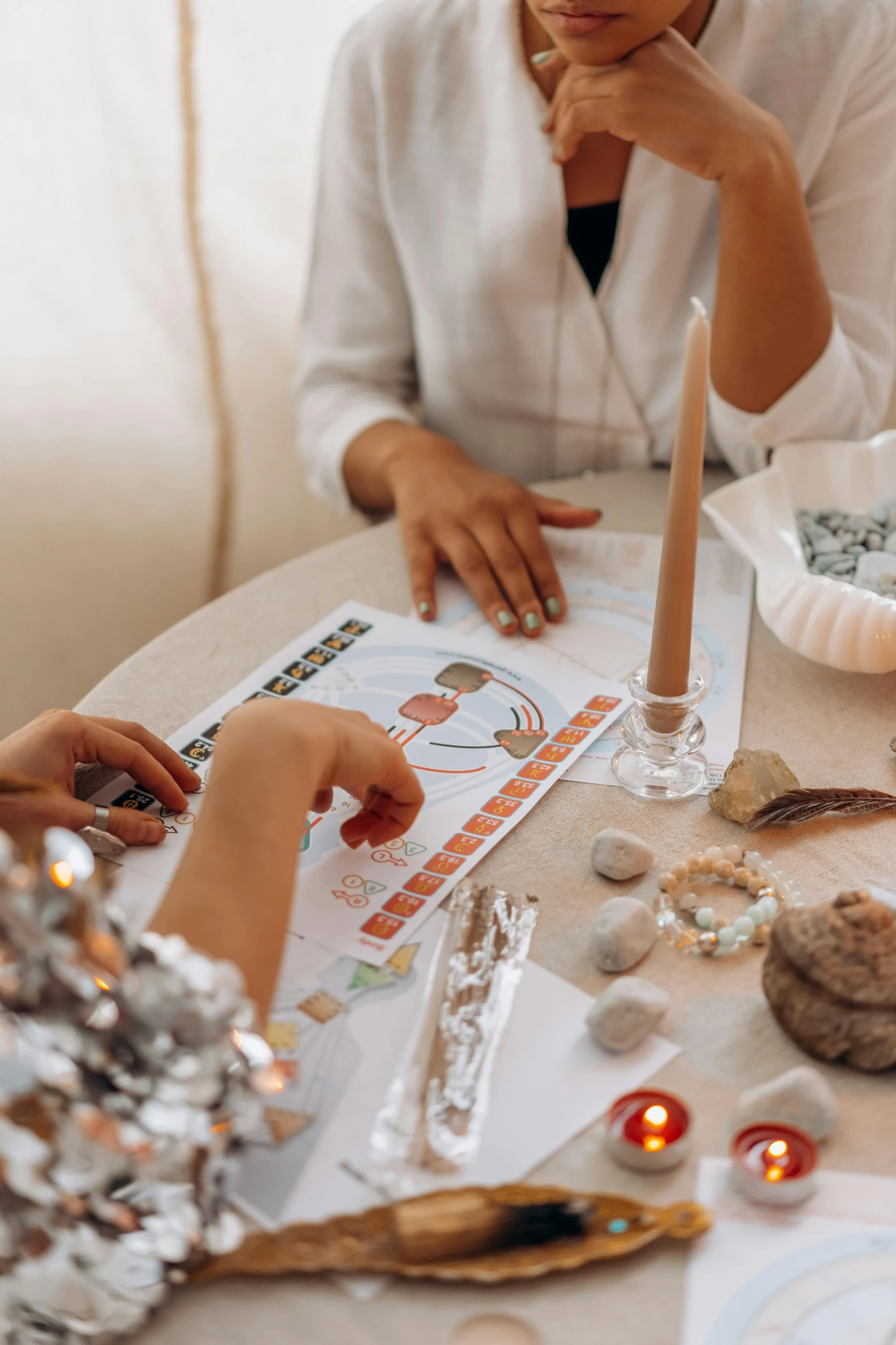 a group of people sitting around a table, a child's drawing, by Julia Pishtar, trending on pexels, wearing silver silk robe, candy decorations, tarot design, white candles