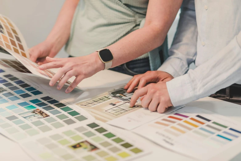 two people looking at color samples on a table, by Carey Morris, trending on unsplash, 9 9 designs, flat neutral tone, hr geiger design, realistic image