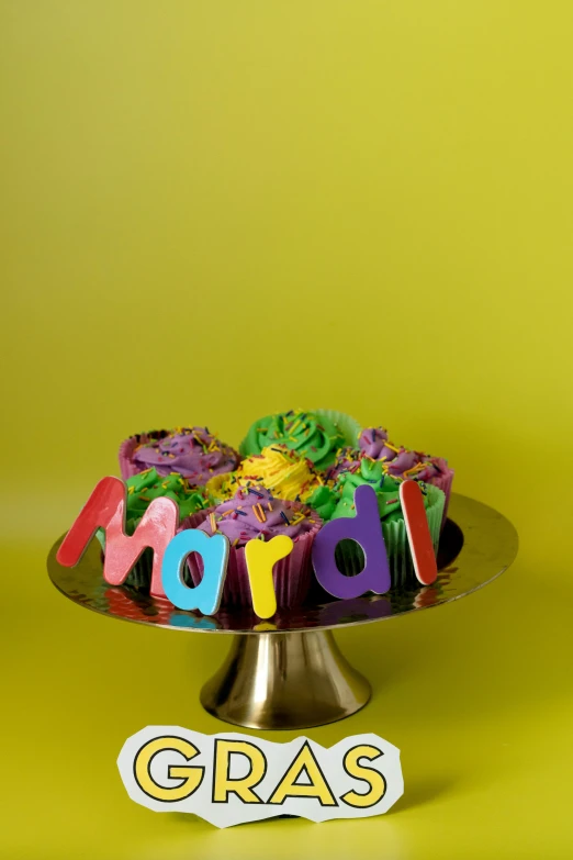 a birthday cake with the word gras on it, by Mardi Barrie, trending on reddit, pop art, bismuth cups, award winning color photo, louisiana, yellow purple green