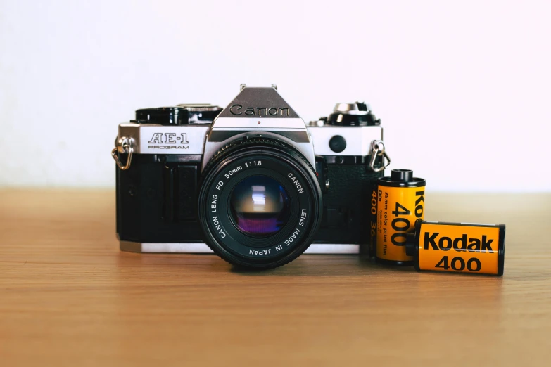 a camera sitting on top of a wooden table, by Adam Rex, pexels contest winner, photorealism, 3 5 mm film kodak 1 9 8 0 s, medium format, 35mm of a very cute, 3 5 mm cooke