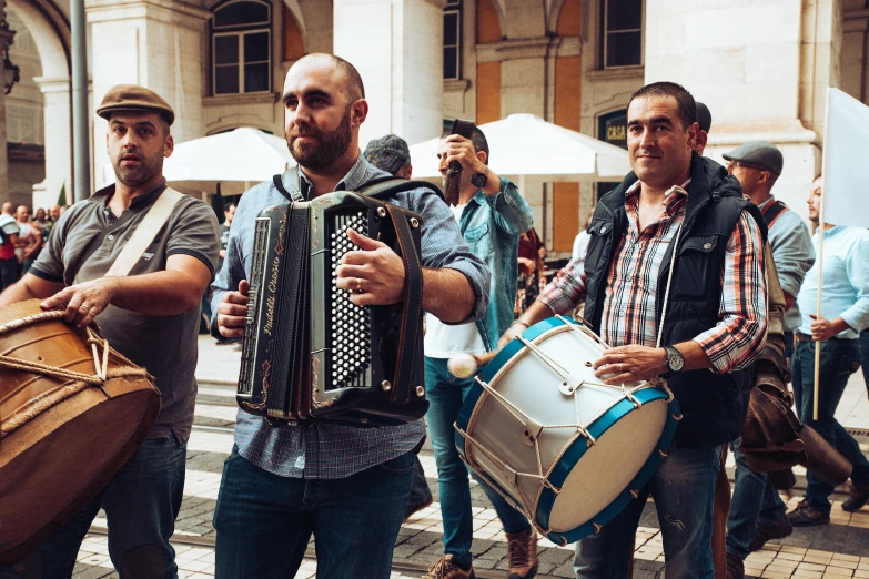 a group of men standing next to each other holding musical instruments, by Lucia Peka, pexels contest winner, in a square, lisbon, 🚿🗝📝