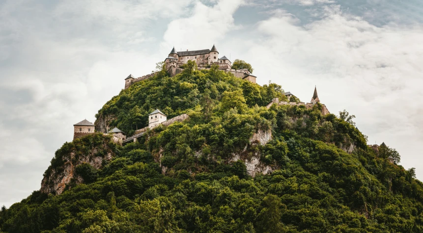 a mountain with a castle on top of it, pexels contest winner, renaissance, covered with vegetation, austro - hungarian, thumbnail, brown