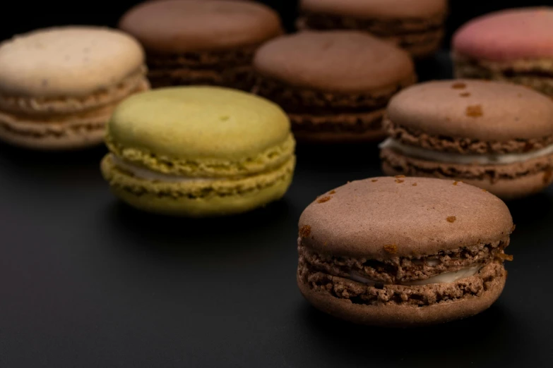 a bunch of macarons sitting on top of a table, dark earthy colours, thumbnail, 8k 50mm iso 10, highly microdetailed