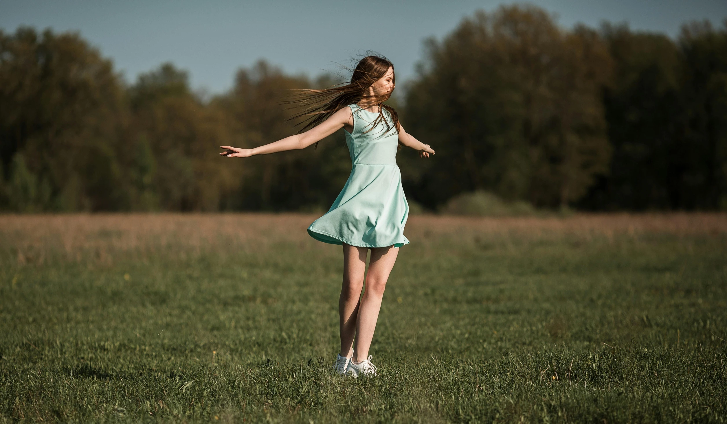 a woman standing on top of a lush green field, by Sebastian Spreng, pexels contest winner, magic realism, she is dancing. realistic, teenager girl, pale blue, 15081959 21121991 01012000 4k