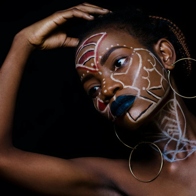 a close up of a person with a painted face, by Lily Delissa Joseph, pexels contest winner, afrofuturism, striking pose, ( ( brown skin ) ), geometry, young lady