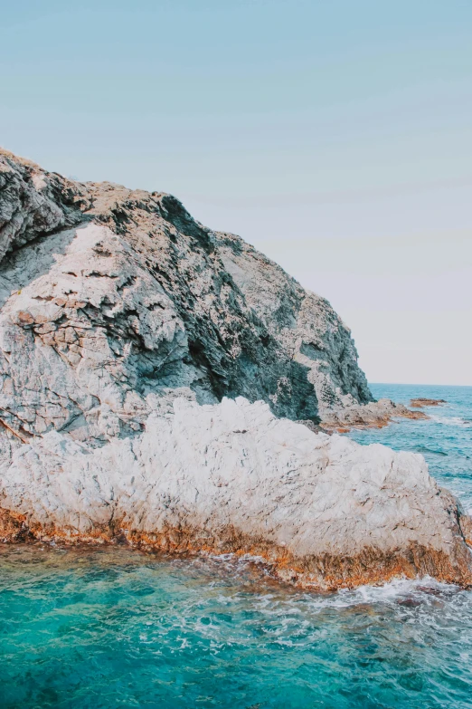 a large rock in the middle of a body of water, by Matt Cavotta, trending on unsplash, romanticism, croatian coastline, slide show, bleached colors, profile pic