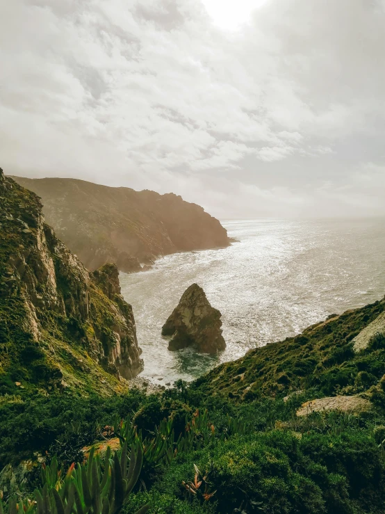 a large body of water sitting on top of a lush green hillside, by Lucas Vorsterman, pexels contest winner, sea storm and big waves cliffs, portugal, slide show, grainy quality