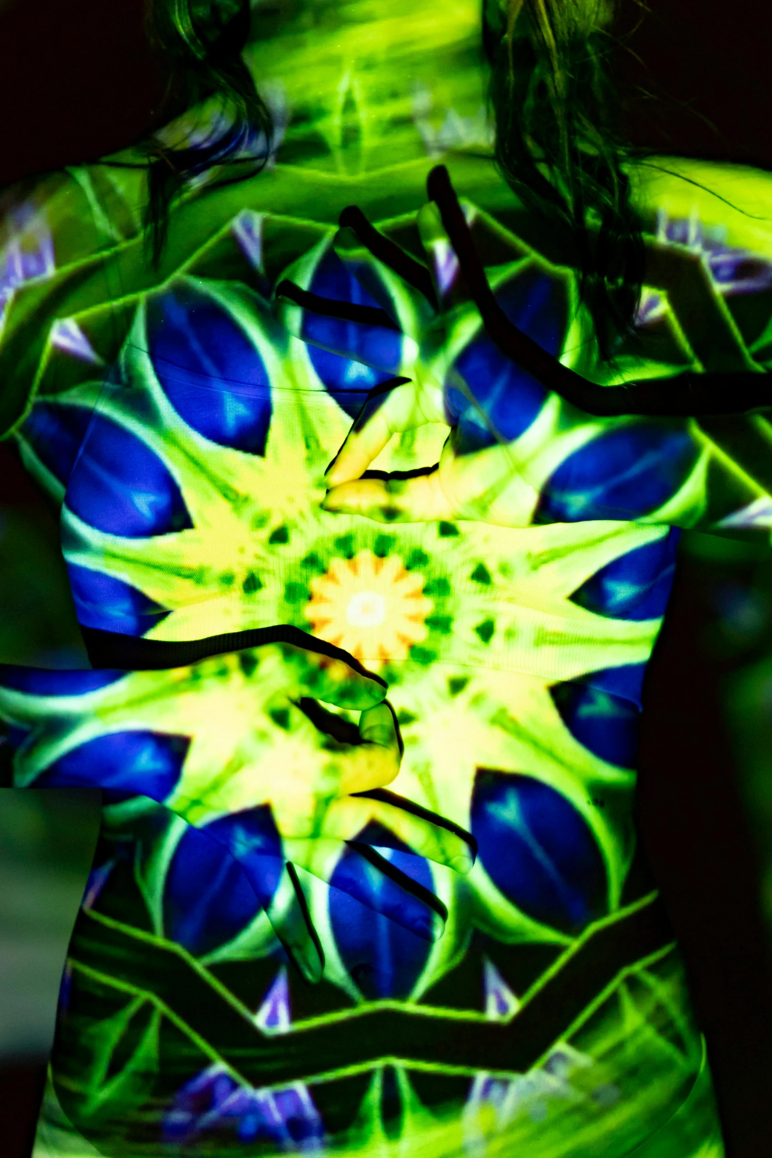 a woman with green and blue paint on her body, an album cover, inspired by Alex Grey, nuclear art, with fractal sunlight, taken in the late 2000s, graphic detail, rave outfit