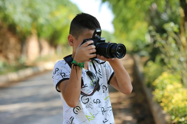 a boy taking a picture with a camera, a picture, pexels contest winner, mohamed chahin style, avatar image, outdoor photo, zoomed in shots