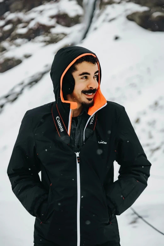 a man standing on top of a snow covered slope, featured on reddit, long and orange mustache, wearing a black hoodie, portait photo profile picture, asher duran