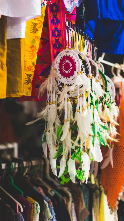 a store filled with lots of different types of clothing, by Gwen Barnard, pexels contest winner, arts and crafts movement, feather native american headgear, dreamcatcher, white, a green