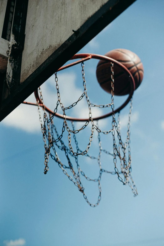 a basketball going through the hoop of a basketball court, an album cover, by Matija Jama, pexels contest winner, 15081959 21121991 01012000 4k, in a sunny day, faded worn, hanging