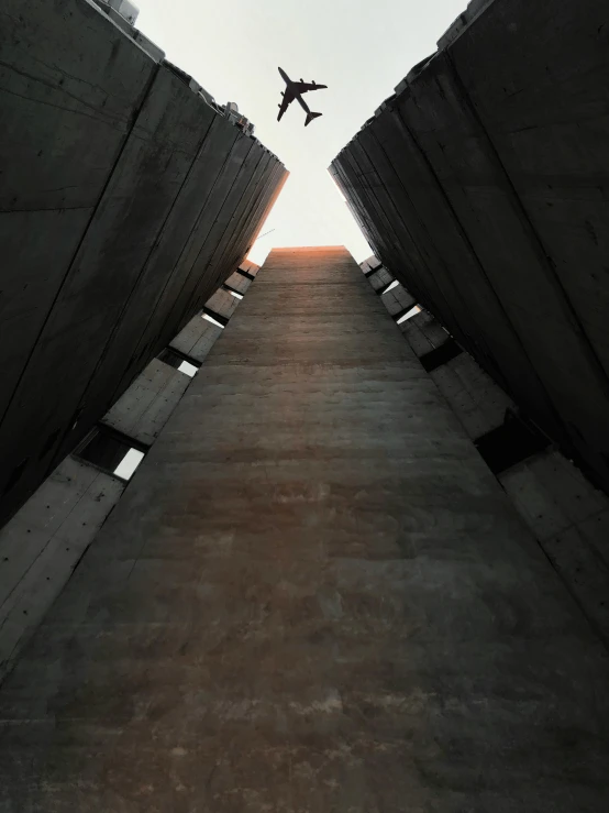 a plane that is flying through the air, an album cover, unsplash contest winner, brutalism, silo, jump, 2 0 0 0's photo, deep chasm