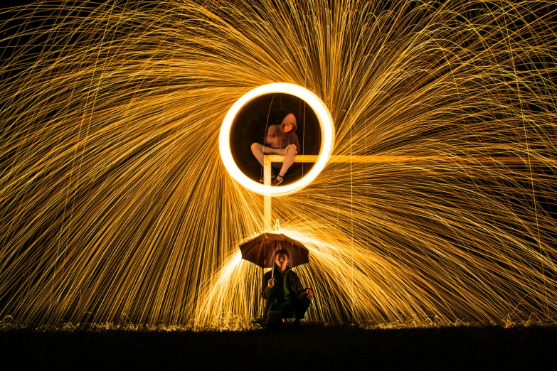 a couple of people sitting under an umbrella, by Jan Rustem, pexels contest winner, swirls of fire, ring light, well balanced composition, large electrical gold sparks