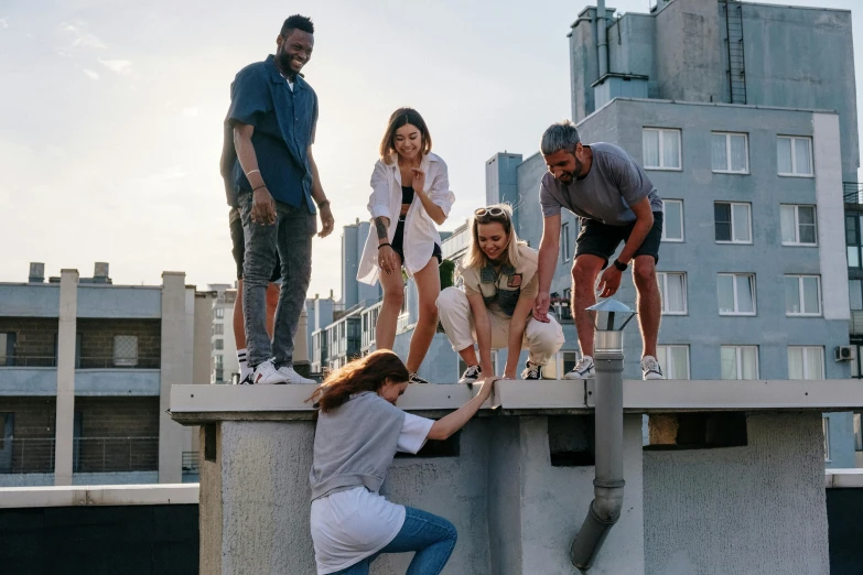 a group of people standing on top of a building, having fun, sitting on top a table, head down, alana fletcher