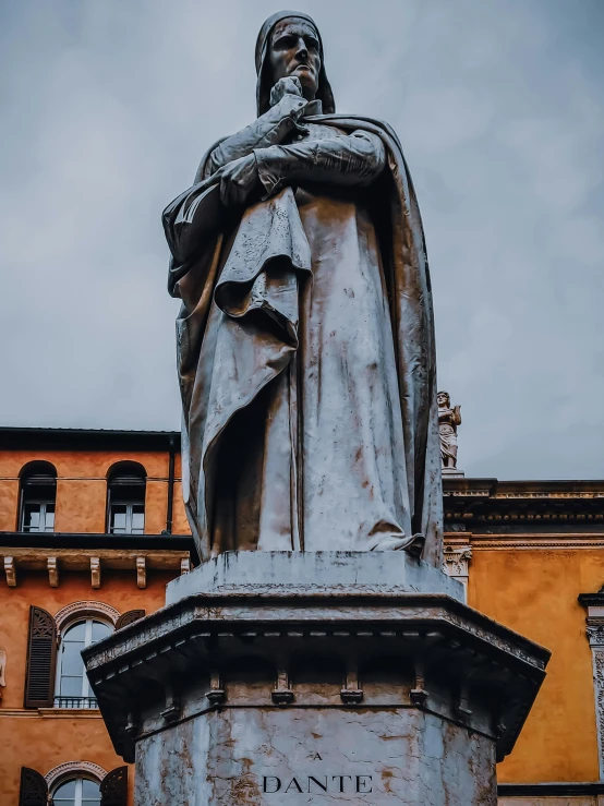 a statue of a man standing in front of a building, inspired by Giovanni Battista Innocenzo Colombo, pexels contest winner, wearing a grey robe, overlooking, italian, looking from side!