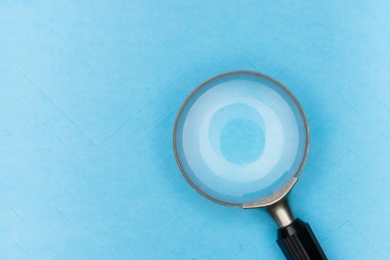 a magnifying glass on a blue surface, trending on pexels, light blue pastel background, instagram post, black and teal paper, medical