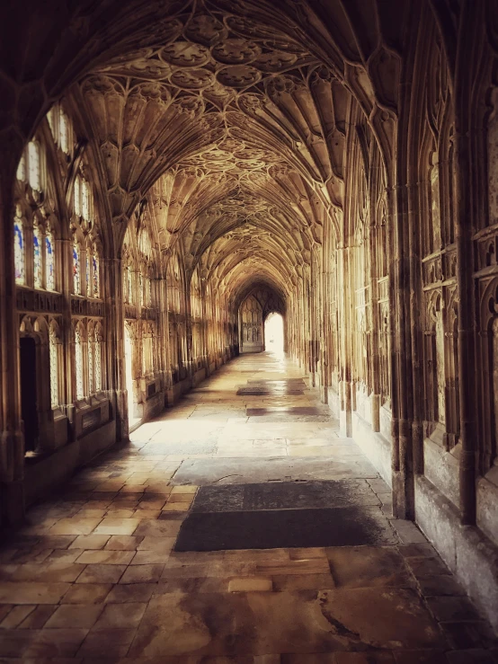 a very long hallway in a very old building, by Rachel Reckitt, unsplash contest winner, renaissance, alabaster gothic cathedral, hogwarts setting, seen from outside, pink marble building