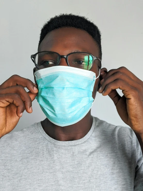 a man wearing a face mask while talking on a cell phone, an album cover, by Everett Warner, trending on pexels, ( ( eye glasses ) ), surgical supplies, diverse, closeup - view