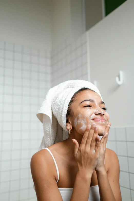 a woman is shaving her face in the bathroom, trending on pexels, essence, wearing a white bathing cap, thumbnail, 1450