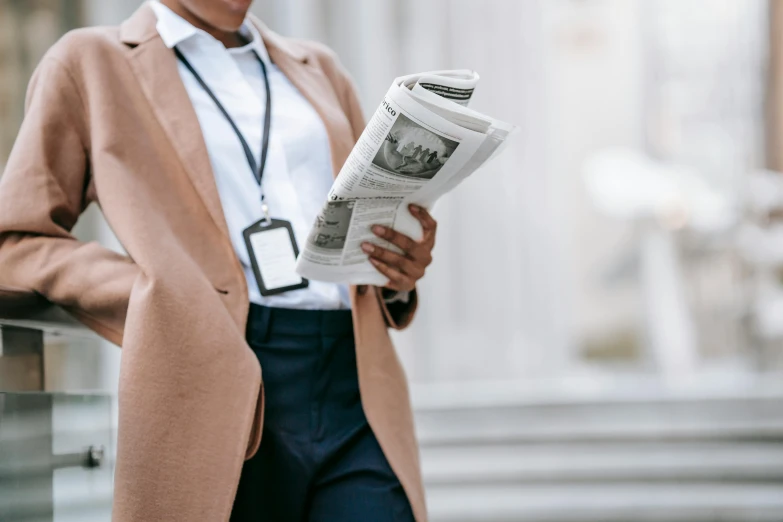 a close up of a person holding a newspaper, by Emma Andijewska, trending on pexels, trench coat and suit, female lawyer, large highlights, thumbnail