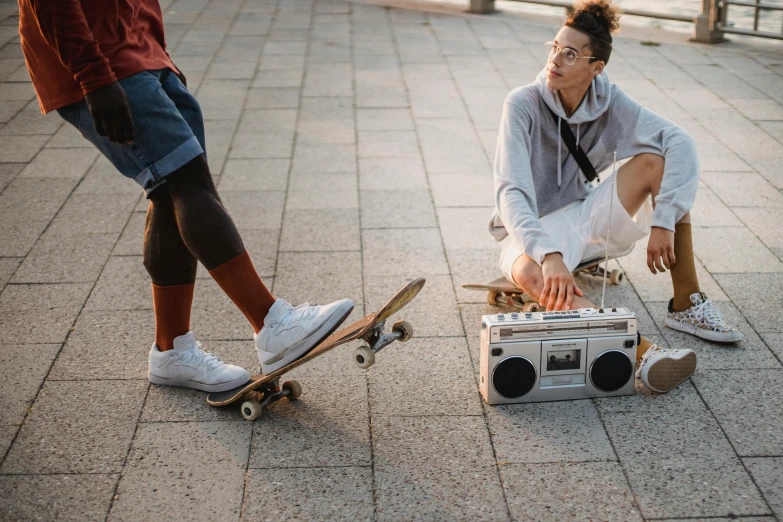 a man sitting on a skateboard next to another man on a skateboard, trending on pexels, happening, boombox, cassette, in a square, 15081959 21121991 01012000 4k