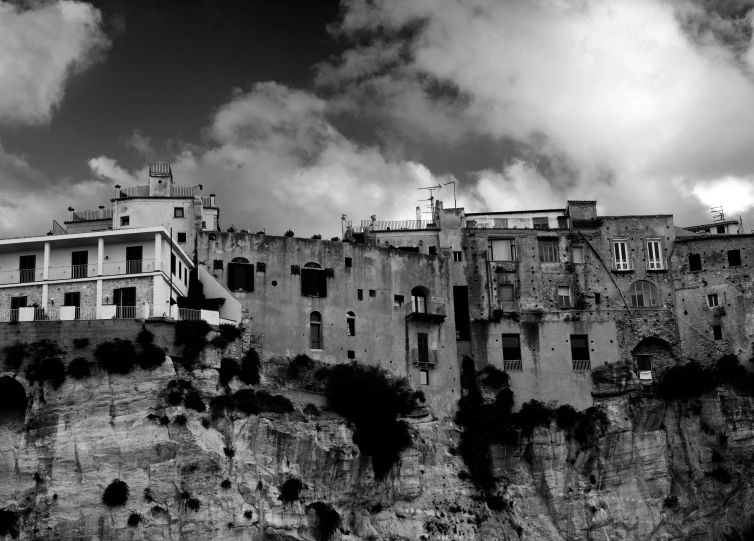 a black and white photo of a castle on a cliff, a black and white photo, by Giovanni Pelliccioli, surrealism, white houses, mediterranean city, photographic print, poor